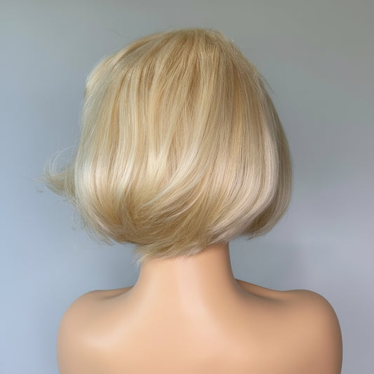 Blonde wig on a mannequin head against a plain background