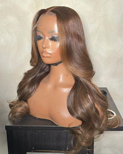 Brown wig on a mannequin head against a neutral background