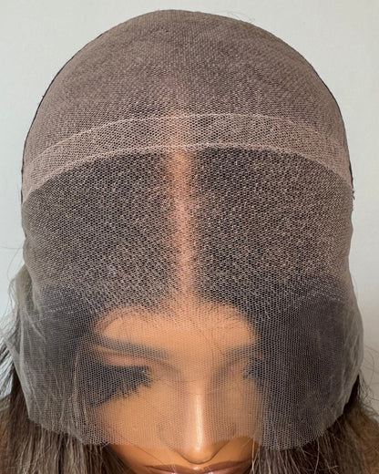 Close-up of a wig with a lace front on a plain background