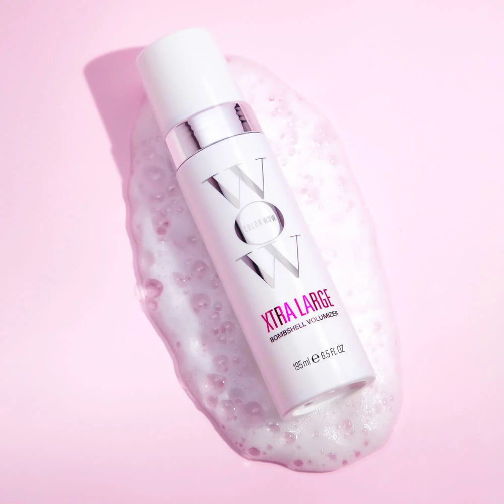 White bottle with pink label on a pink background