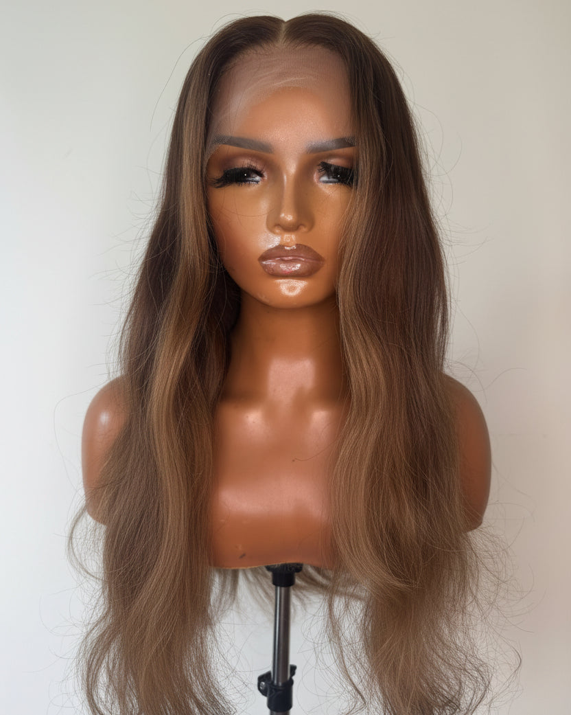 Mannequin head with long brown wig on a plain background