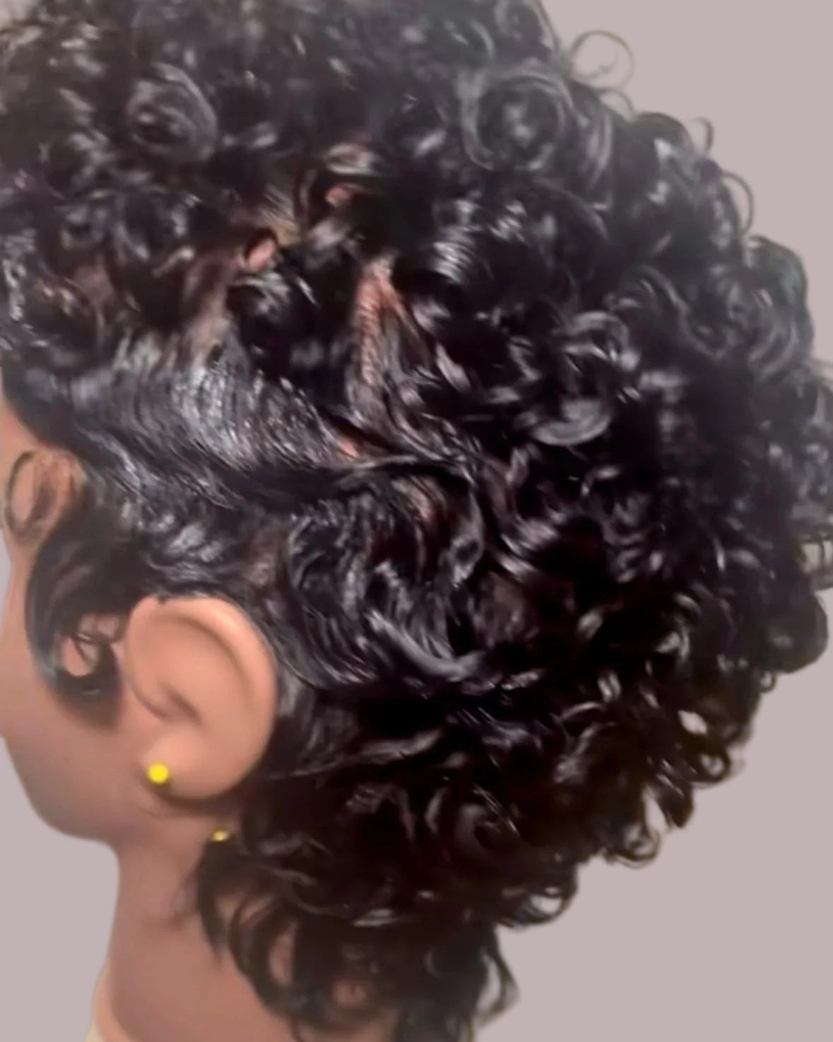 Mannequin head with curly black hair on a plain background - The Hair Source