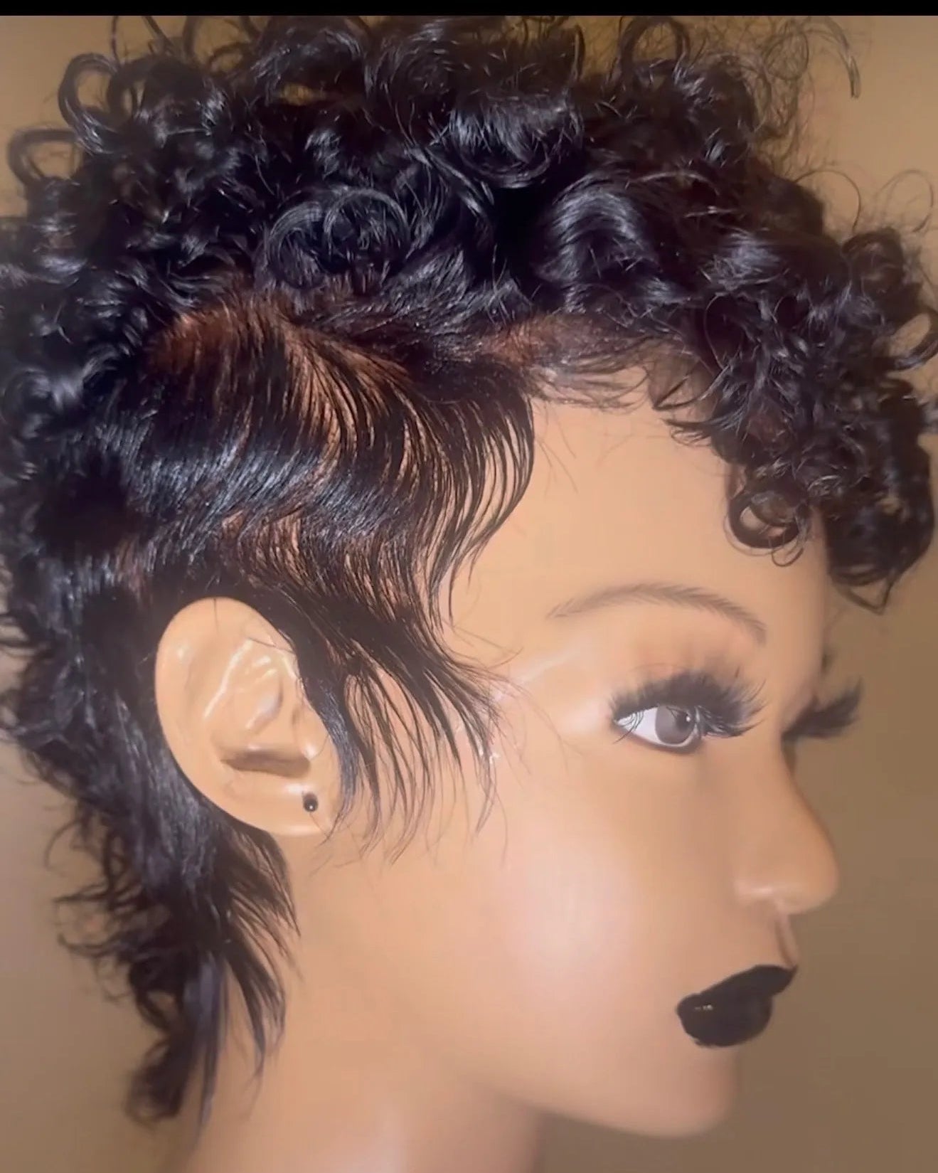 Mannequin head with a short, styled black wig on a beige background - The Hair Source