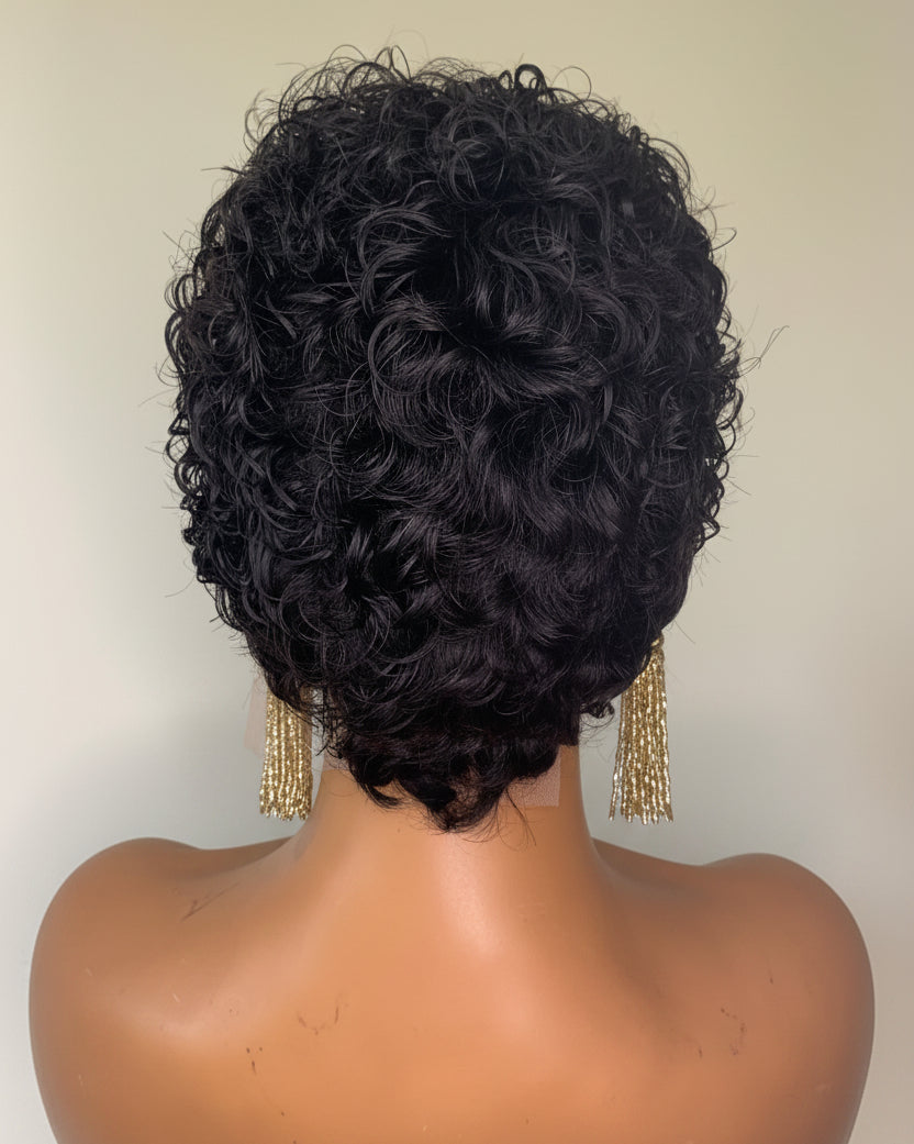 Black curly wig on a mannequin head against a plain background