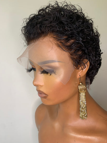 Mannequin head with black curly hair and gold earring on a white background
